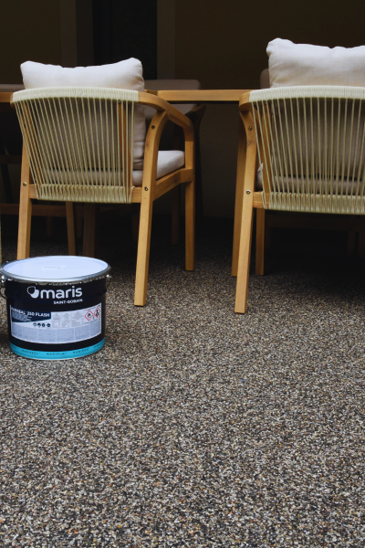 Steinteppich Komplett Set verlegt auf einer Terrasse mit Möbeln im Außenbereich - Bauchemie.at Onlineshop